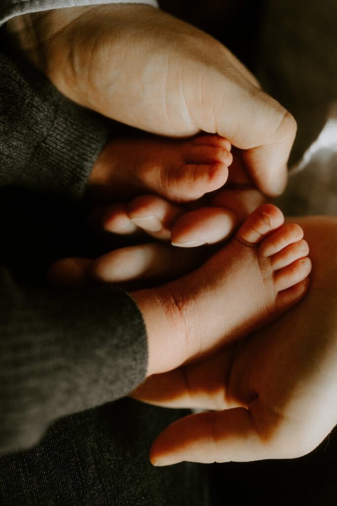 Babyfüße in den Händen der Eltern, Detailaufnahme